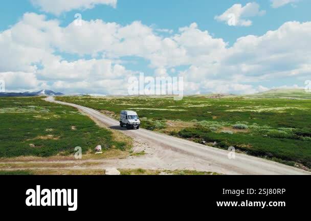 Side drone shot of adventure campervan with spare tire on back, solar ...