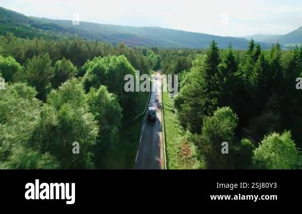 Aerial drone camera follows a grey off road overlanding van with solar ...