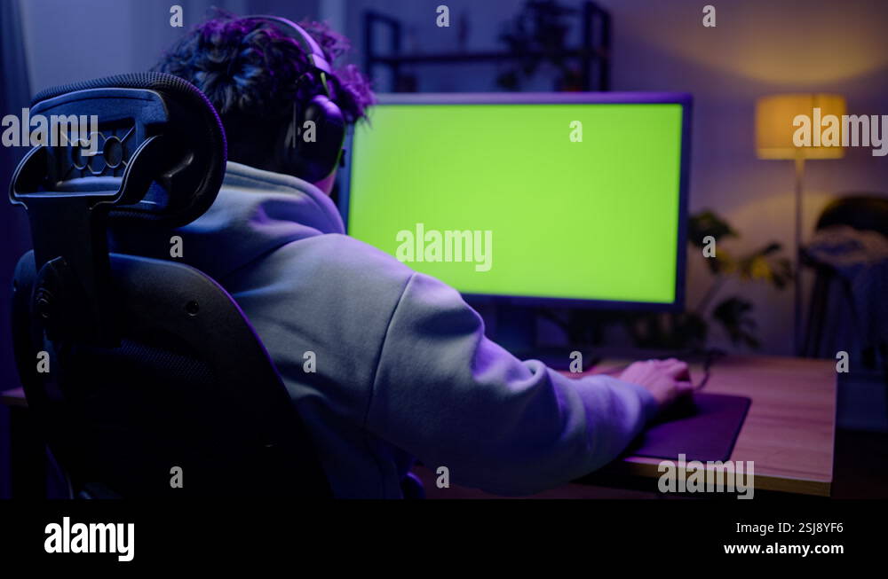 Rear view of gamer experiencing stress while losing online video game ...