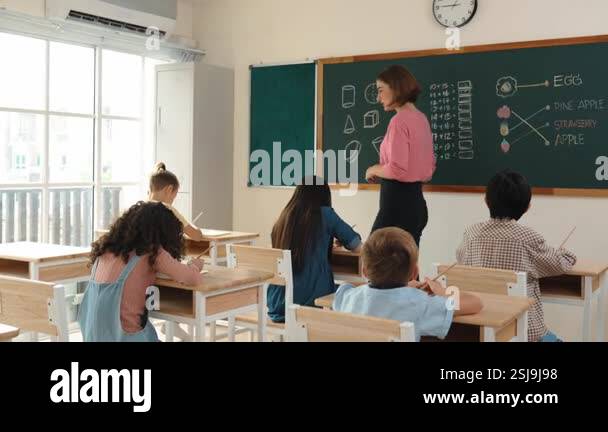 Instructor With Notebook Smart teacher checking cute student homework while explaining idea at ...