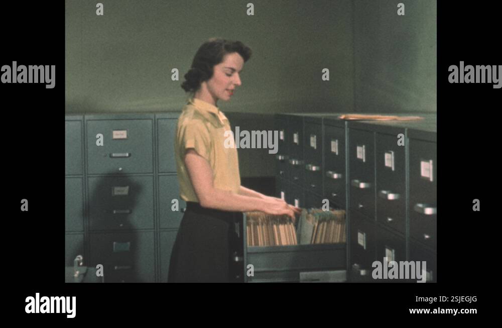 1960s: Electronics schematic displays on microfiche reader. Hand holds ...