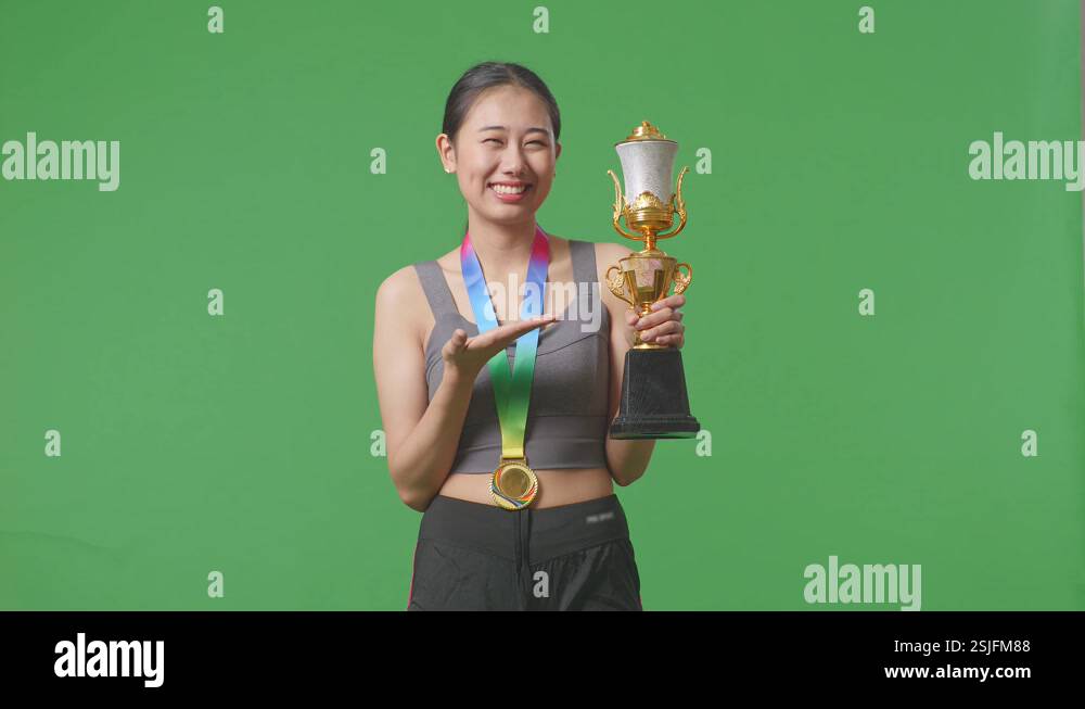 Asian Woman With A Gold Medal Pointing To A Gold Trophy In Her Hand And ...
