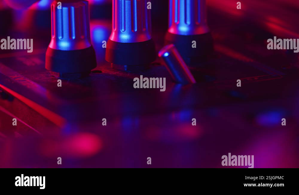 DJ carefully flips the toggle switch and turns the knob on a mixer to ...