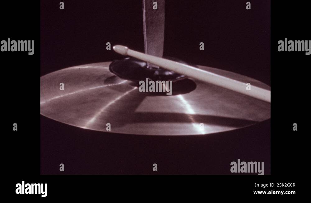 1950s: Cymbal, drum stick hits cymbal. Person stops cymbal from ringing ...