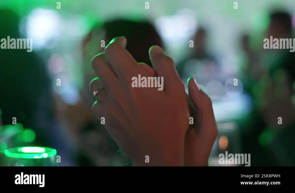 Detail of the hands of a man clapping at a party, shot in slow motion ...