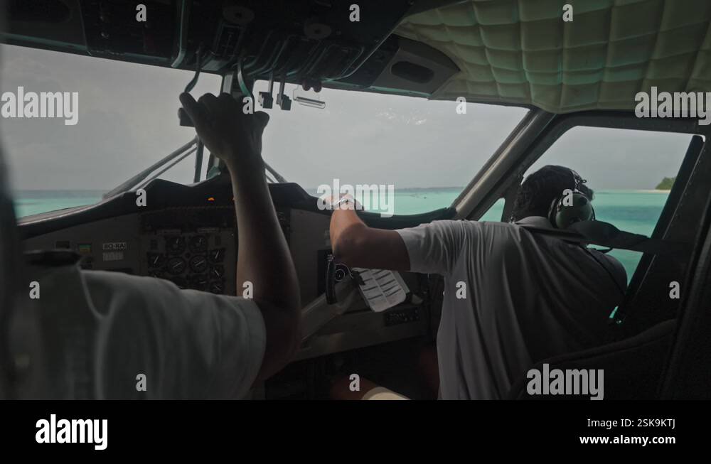 Pilot looking out of window at seaplane engines during start of take ...