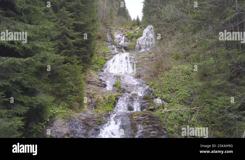 Aerial view of Rausor Waterfall. Long cascades of cool water crash down ...