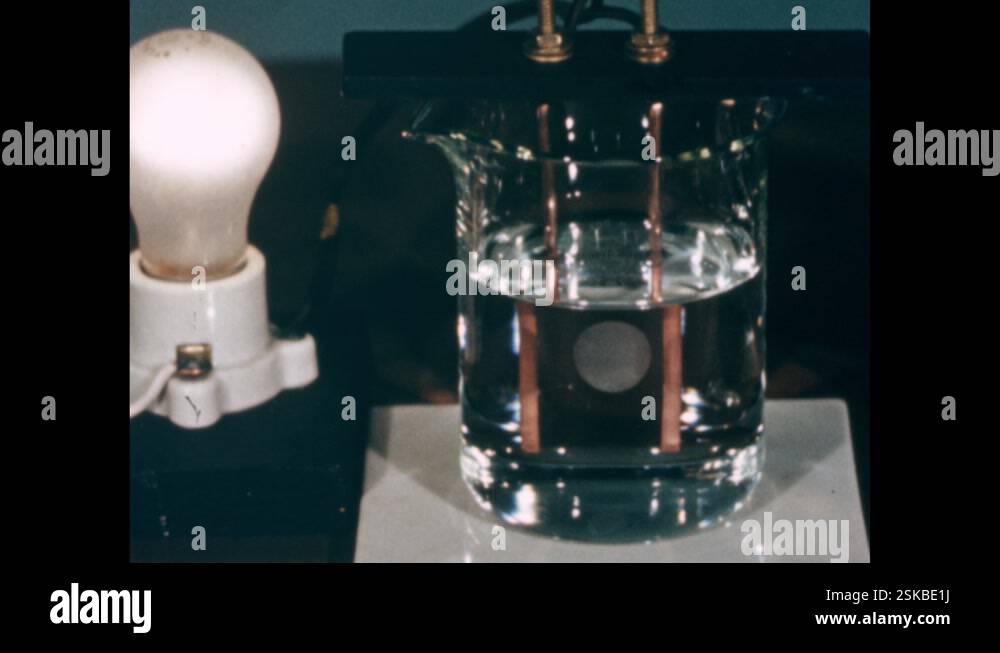 1960s: Lightbulb is lit while wires going into glass of water Stock ...