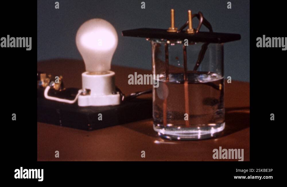 1960s: Lightbulb is lit while wires going into glass of water Stock ...