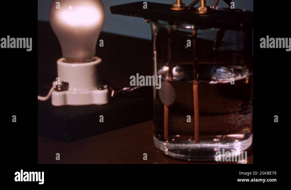1960s: Lightbulb is lit while wires going into glass of water Stock ...