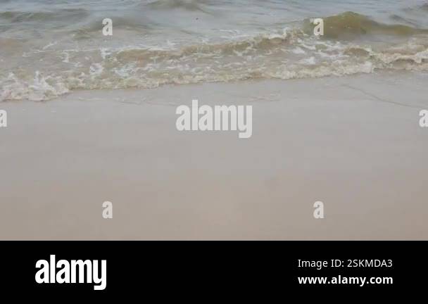 white sand beach while sea wave hit the surface on sandy beach in sunny ...