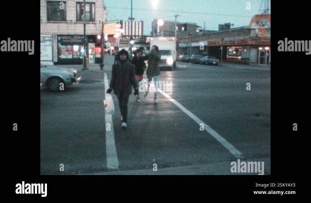 1980s: Teen boy and girl on date walk down street. Boy talks ...
