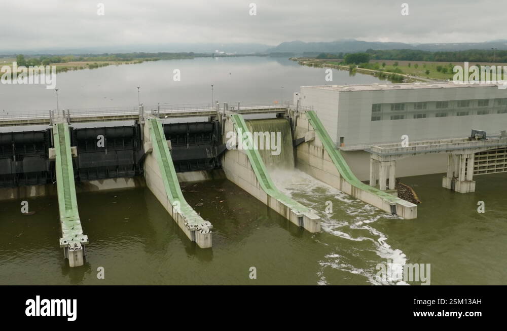 Expansive dam infrastructure with water release against a scenic ...