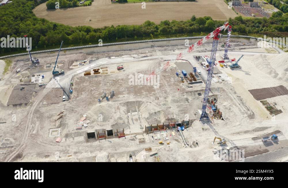Aerial drone rotating shot over a construction site alongside cranes ...