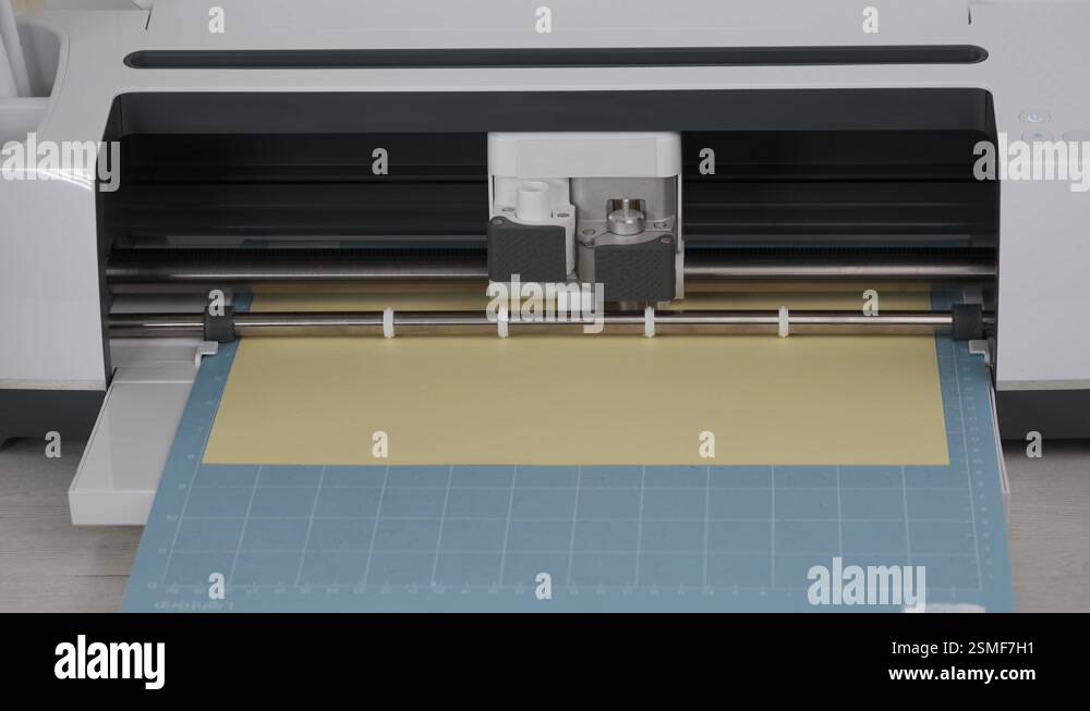 Cutting machine cut out details on yellow cardboard on blue mat Stock ...