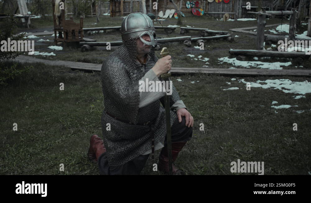 Knight in Chainmail and Helmet Kneeling with Sword to Pray before ...