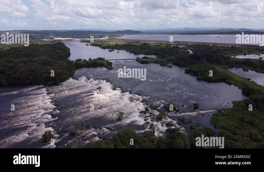 A slow aerial tracking shot along the Caroní River, capturing its green ...