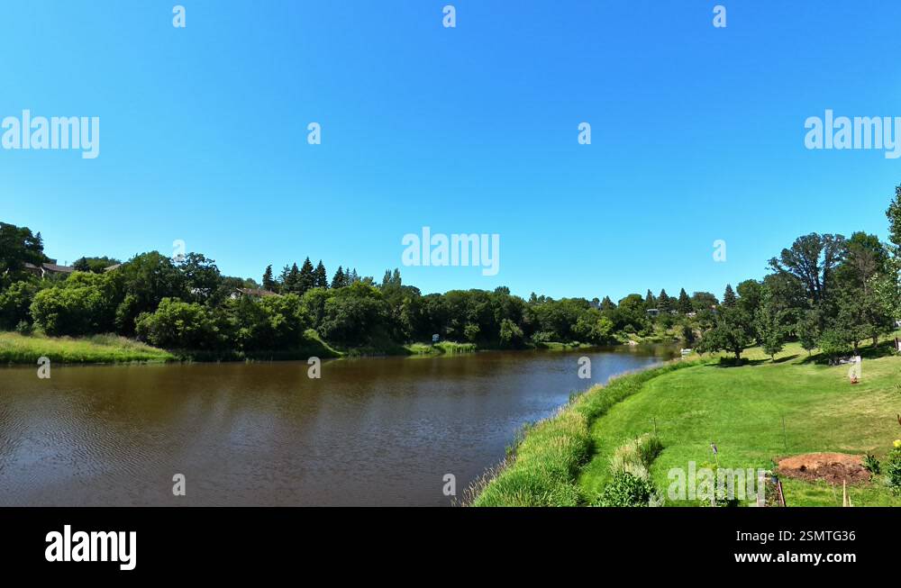 Serene river landscape with lush green meadows, tree-lined banks, and a ...