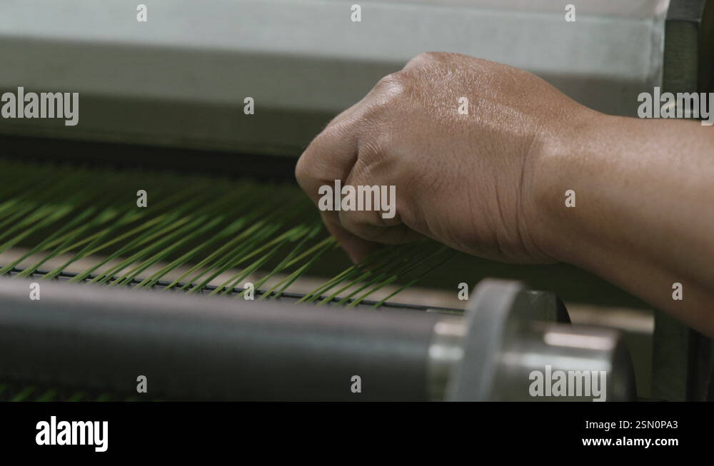 Close up footage of a hand and fingers working on thread that is moving ...