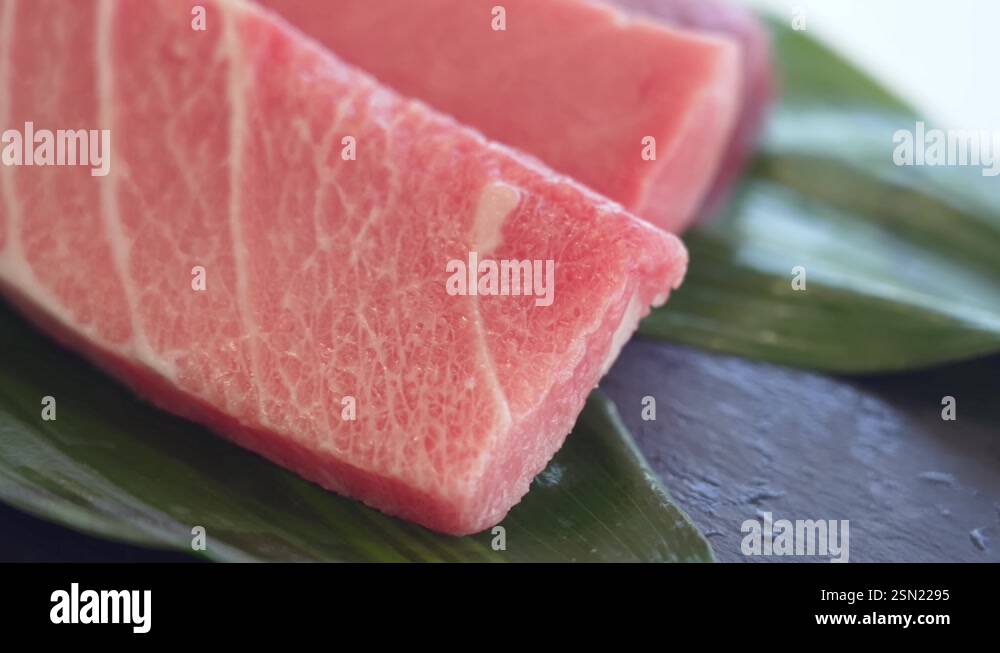 Piece of Tuna Fish Rotating on a Black Stone Background. Raw Tuna Steak ...