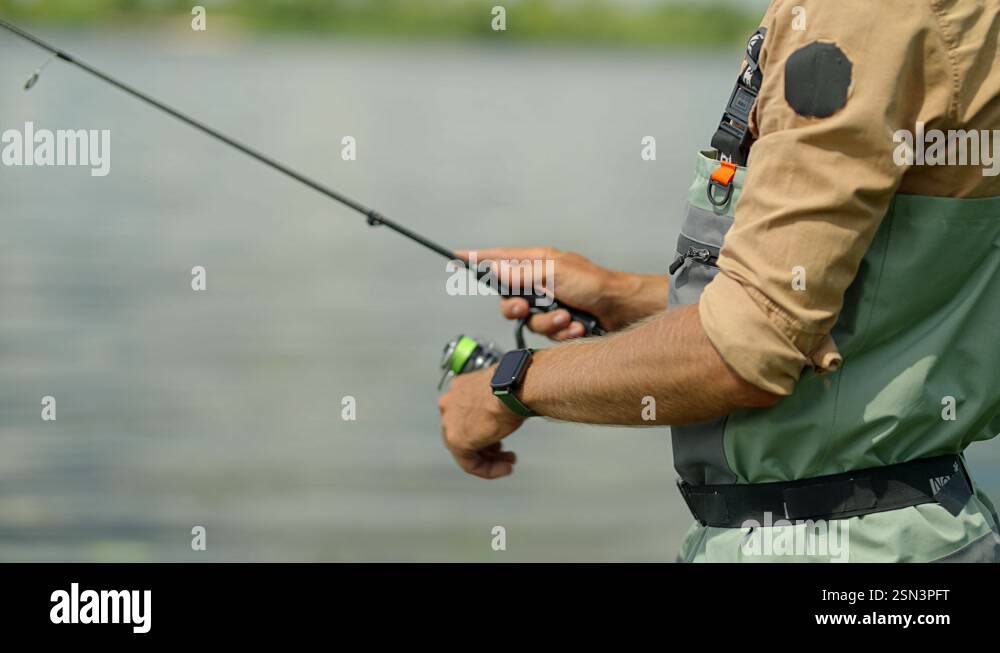 Fisherman With Rod Tackles. Fisher In Waders. Angler Catching Fish ...