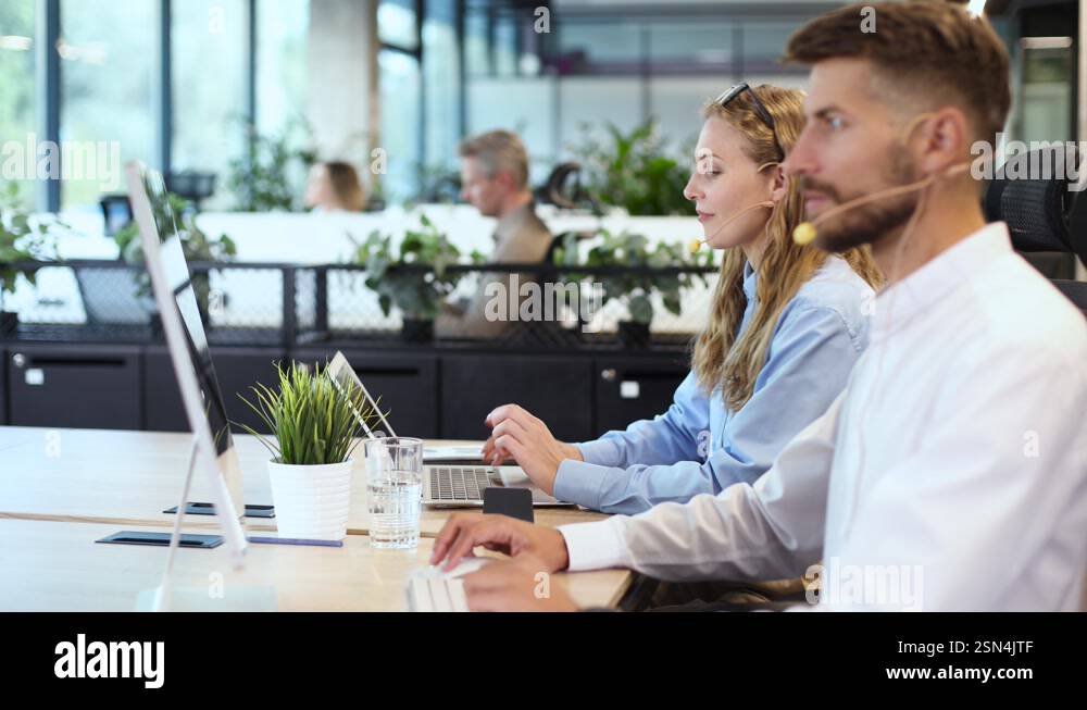 Man and colleagues in a call center office for customer service help ...