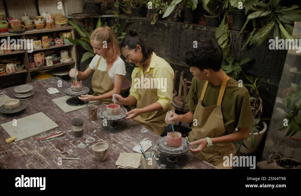 View of Teacher Helping Teenagers with Crafting and Decorating Clay Bowls Stock ...
