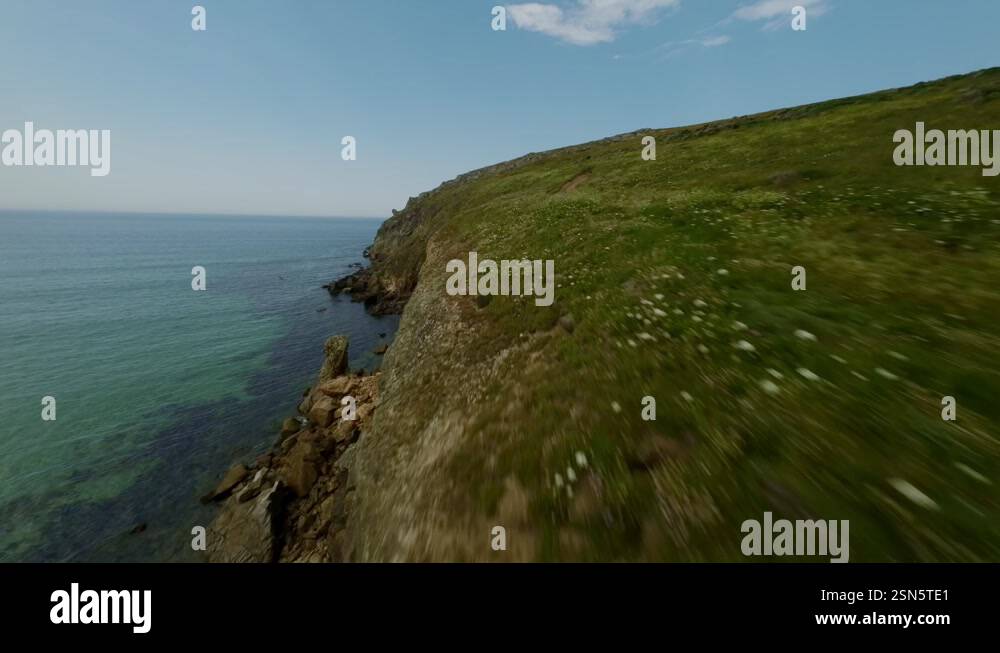 FPV drone captures a sweeping view over the green hills and beaches of ...