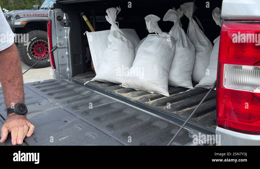 Tampa, United States - 10/17/2024: Man loading sandbags into pickup ...