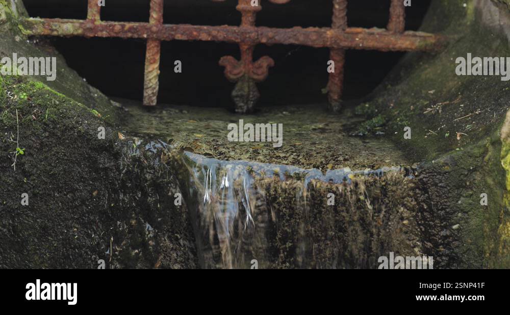 Water rushing out of an old stone canal, the water cascading over a ...