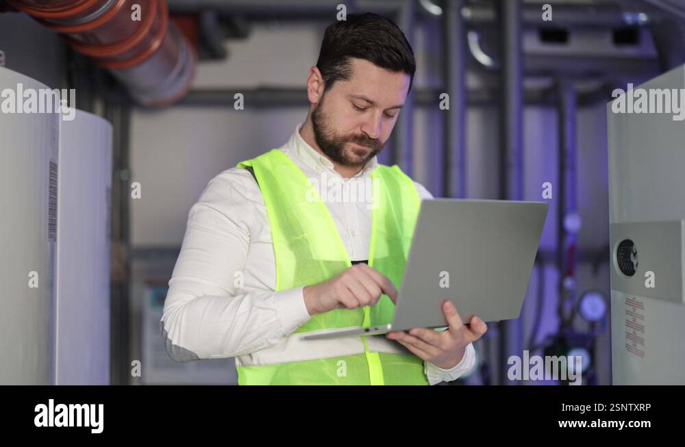 Industrial HVAC Engineer Uses Laptop in Boiler Room to Check Heating ...