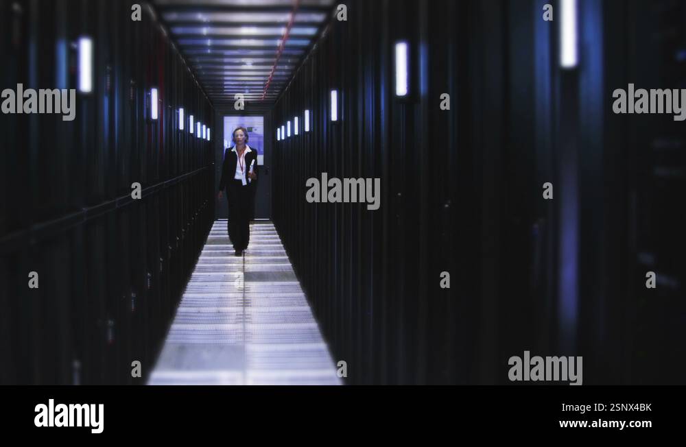 People working in computer server room data center. Walking along rows ...