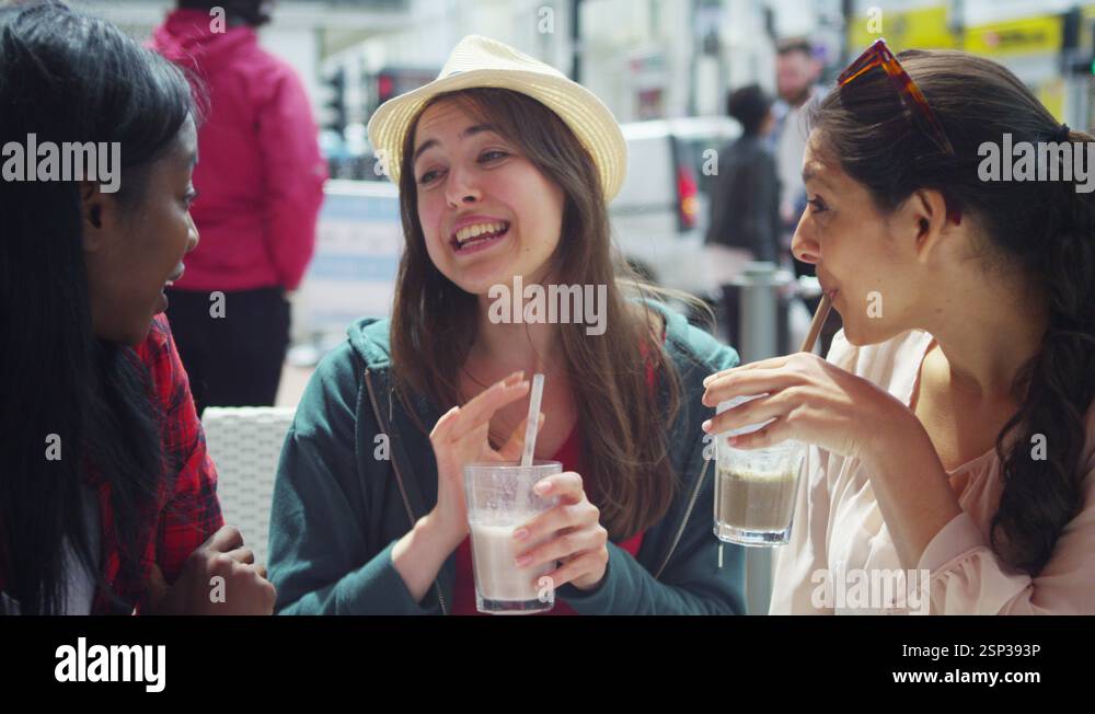 4k Happy female friends chatting at outdoor cafe in the city Stock ...