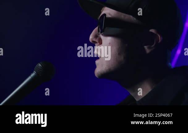 Close up of a rap artist singing on a dark laser background. 4k high ...