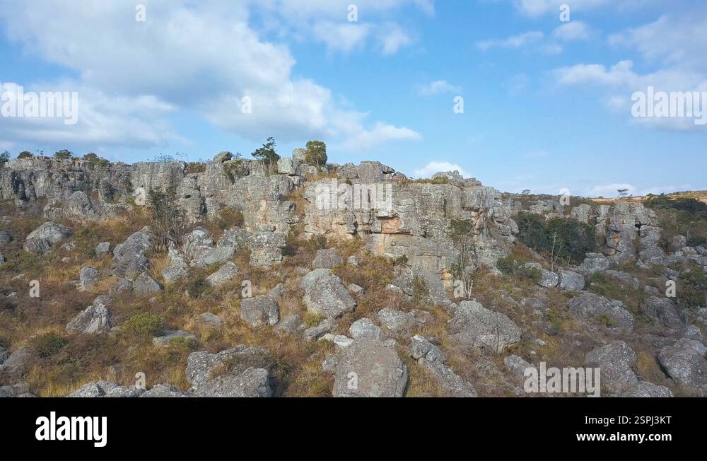 Horizontal pan shot of rocks jutting out of dry grassland Stock Video ...
