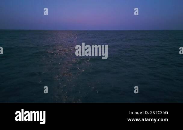 Moonlight reflecting on the calm ocean at night, creating a shimmering ...