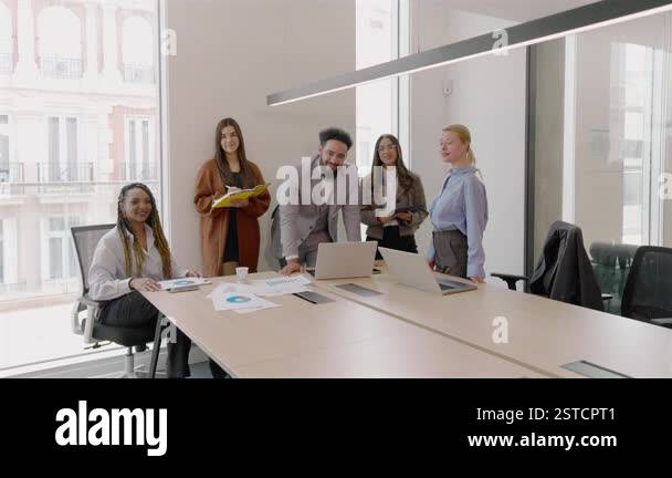 Diverse group of business professionals is engaged in discussions and ...