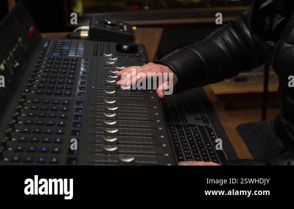 Sound engineering professional carefully adjusting audio mixing console ...