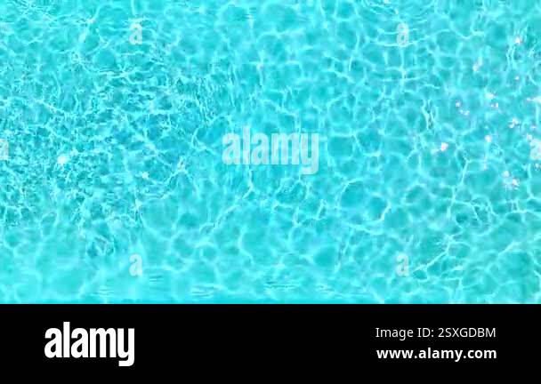 Surface of pure blue water in the swimming pool with light reflections ...
