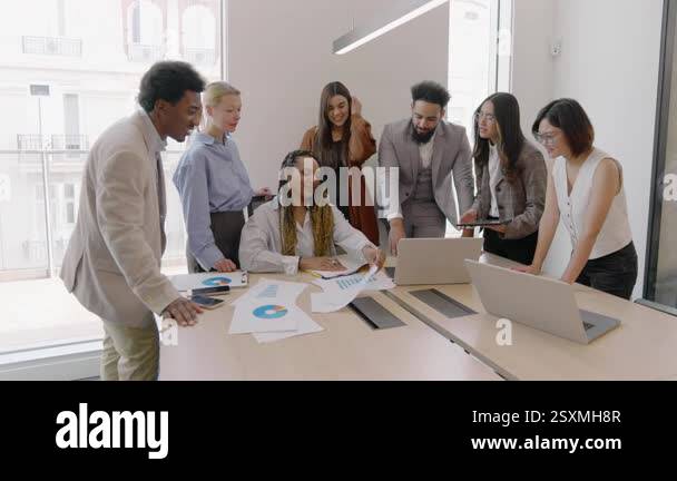 Diverse group of professionals collaborates at a conference table in a ...