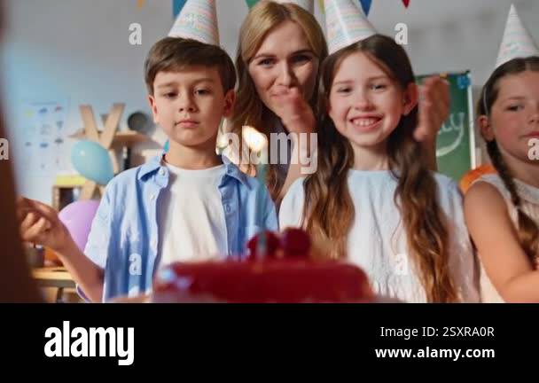 Children celebrating birthday party with teacher and colorful ...