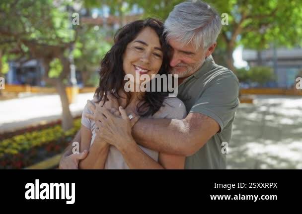 Loving couple embracing outdoors in a sunny urban park showcasing joy ...