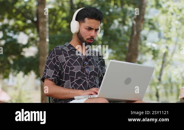 Hispanic young man using laptop computer typing browsing, loses ...