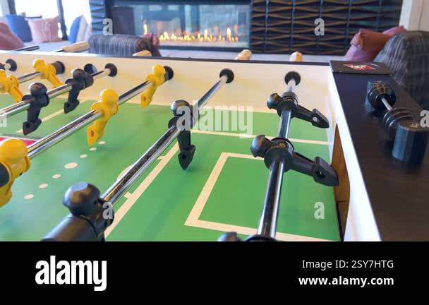 The image captures a foosball table, poised for a friendly match, with ...