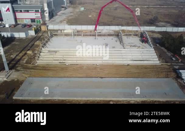 Aerial of concrete boom pump crane arm truck with outriggers pouring ...
