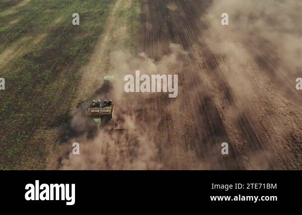 4K drone shooting from above the tractor works in the field and plows ...