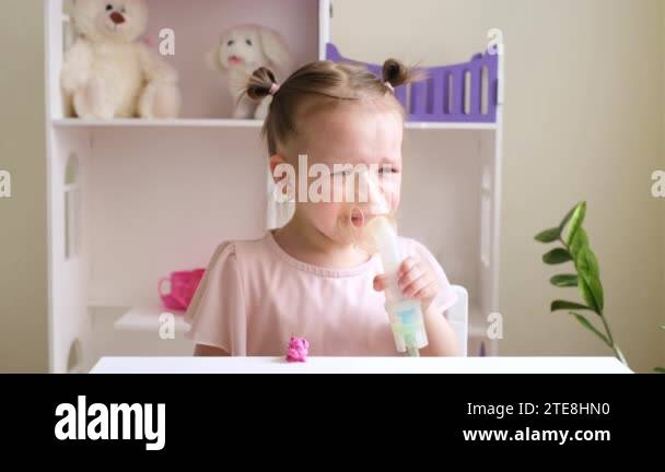 Small child does not like to inhale and breathe steam through a mask ...