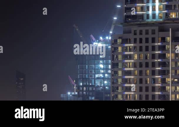 Tall buildings under construction and cranes night timelapse Stock ...