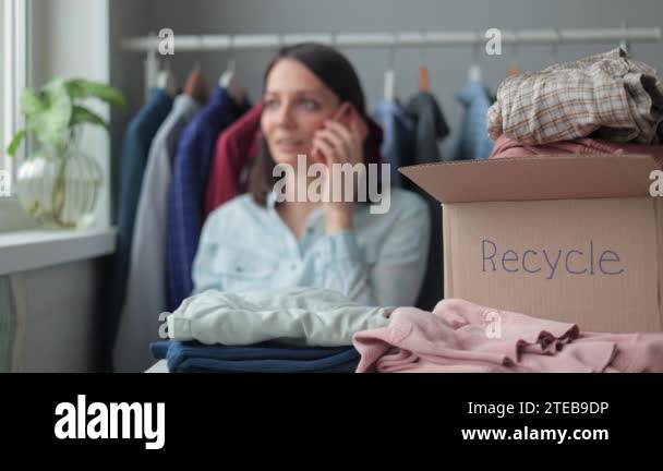a woman collects clothes in a box for recycling or disposal. a ...
