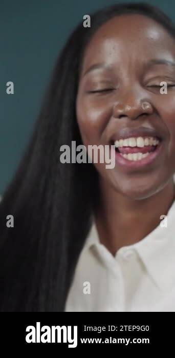 Black female with long hair posing over green studio background